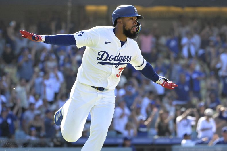 Teoscar Hernández, de los Dodgers de Los Ángeles, corre a primera mientras celebra conectar un sencillo para anotar a Enrique Hernández en la décima entrada contra los Piratas de Pittsburgh el domingo 11 de agosto de 2024, en Los Ángeles. (AP Foto/Jayne-Kamin-Oncea)