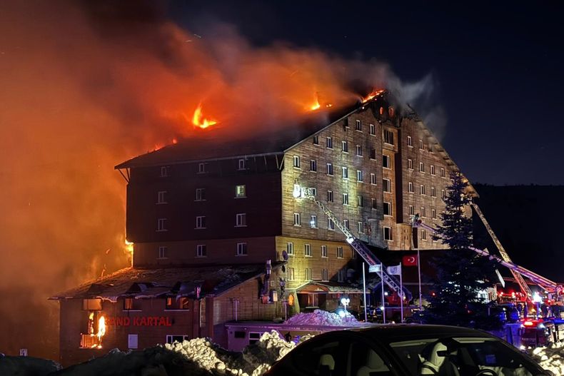 Bomberos trabajan en la extinción de un incendio en un hotel de la estación de esquí de Kartalkaya, en la provincia de Bolu, en el noroeste de Turquía, el 21 de enero de 2025. (IHA vía AP)