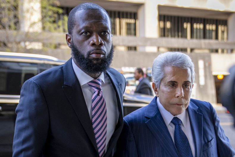 ARCHIVO - Prakazrel Pras Michel, izquierda, integrante del grupo de hip hop de la década de 1990 Fugees, accompañado por el abogado defensor David Kenner, derecha, llega a una corte federal para su juicio por asociación delictuosa para fraude financiero relacionado con política el 30 de marzo de 2023, en Washington. Michel fue declarado culpable el 26 de abril. (Foto AP /Andrew Harnik, archivo)