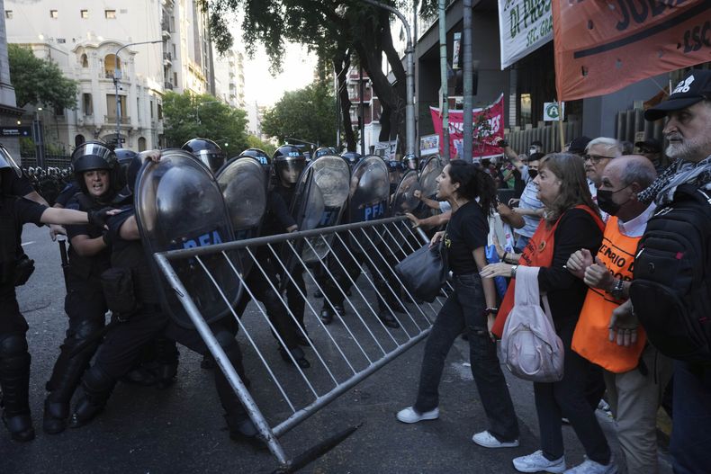 Manifestantes empujan una valla durante enfrentamientos con la policía antidisturbios afuera del Congreso durante las manifestaciones semanales para exigir mejores pensiones para los jubilados y oponerse a las medidas de austeridad del gobierno de Javier Milei, en Buenos Aires, Argentina, el miércoles 26 de marzo de 2025. (AP Foto/Rodrigo Abd)