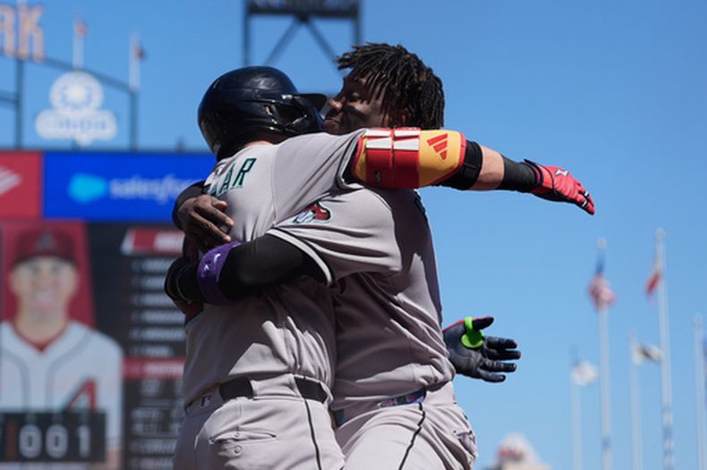 Lars Nootbaar de los Diamondbacks de Arizona felicitado por su compañero Geraldo Perdomo tras su grand slam en la séptima entrada ante los Gigantes de San Francisco en el primer juego de la doble cartelera el sábado 29 de agosto del 2026. (AP Foto/Jeff Chiu)
