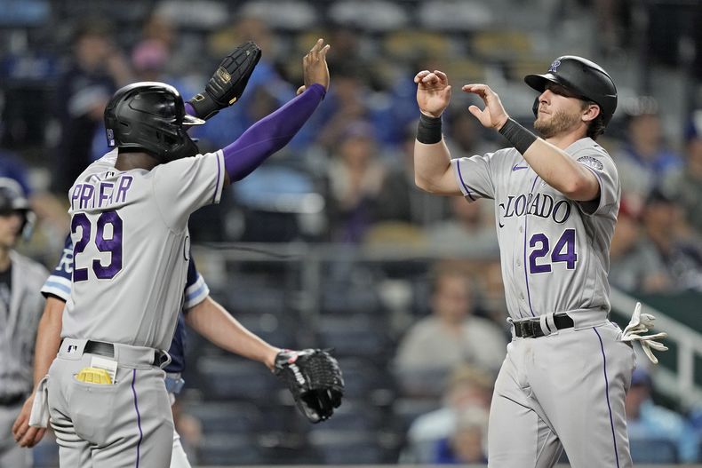 Jurickson Profar (29) y Ryan McMahon (24), de los Rockies de Colorado, celebran después de anotar con doble de Elías Díaz durante la octava entrada del juego de béisbol en contra de los Reales de Kansas City, el viernes 2 de junio de 2023, en Kansas City, Missouri. (AP Foto/Charlie Riedel)