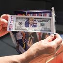 Una persona muestra un billete con la imagen del expresidente Donald Trump el sábado 22 de junio de 2024, antes de un mitin afuera de la Universidad Temple de Filadelfia. (Foto AP/Chris Szagola)