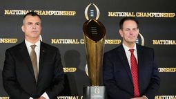 Mario Cristobal, izquierda, entrenador de Miami, y Curt Cignetti, head coach de Indiana, posan con el trofeo del fútbol americano universitario, previo al juego de campeonato de la NCAA entre Miami e Indiana, el domingo 18 de enero de 2026, en Miami. (AP Foto/Chris Carlson)