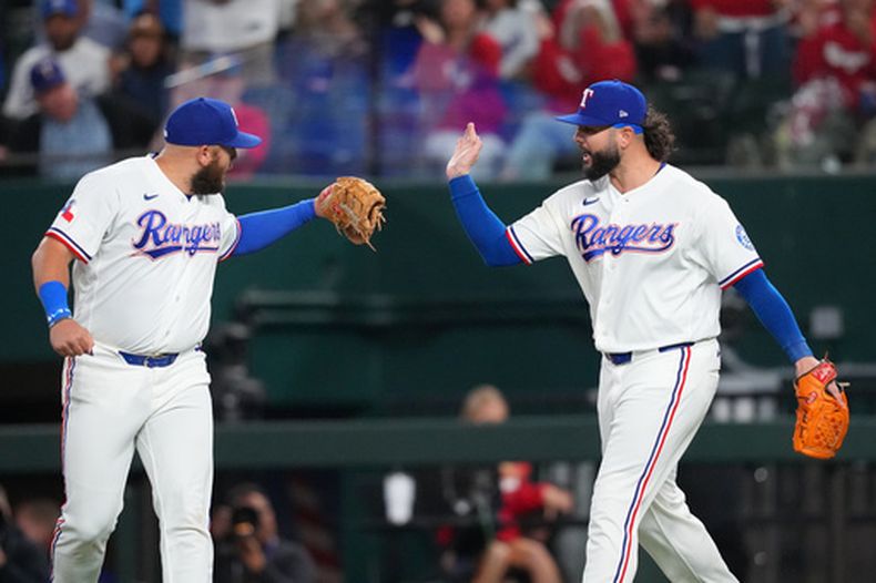 El primera base de los Rangers de Texas Jake Burger saluda al pitcher Jakob Junis tras vencer a los Marineros de Seattle el lunes 6 de abril del 2026. (AP Foto/Julio Cortez)