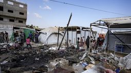 Palestinos inspeccionan los daños causados por un bombardeo israelí contra un campamento ubicado en el patio del Hospital Mártires de Al Aqsa, en Deir al-Balah, el domingo 4 de agosto de 2024. (AP Foto/Abdel Kareem Hana)