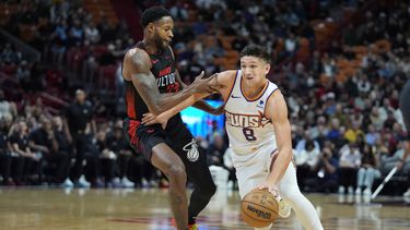 Grayson Allen (8), de los Suns de Phoenix, lleva el balón pasando sobre la marca de Haywood Highsmith (24), del Heat de Miami, durante la primera mitad del juego de baloncesto de la NBA, el lunes 29 de enero de 2024, en Miami. (AP Foto/Wilfredo Lee)