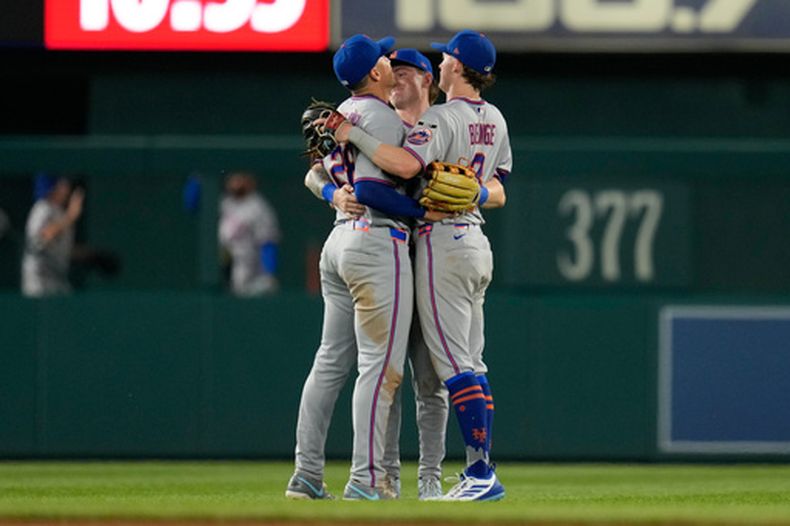 Tyrone Taylor, A.J. Ewing y Carson Benge de los Mets de Nueva York celebran la victoria en la 12ma entrada ante los Nacionales de Washington el lunes 18 de mayo del 2026. (AP Foto/Jess Rapfogel)