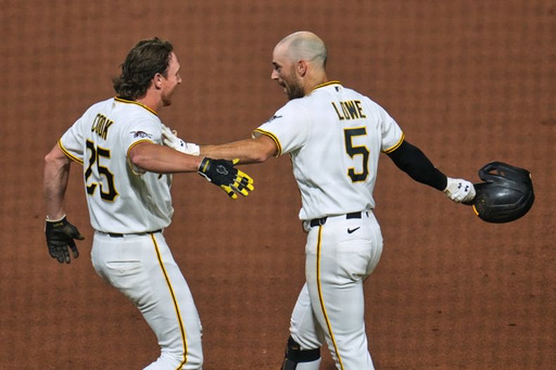 Brandon Lowe (5), de los Piratas de Pittsburgh, celebra con Billy Cook (25) después de remolcar la carrera decisiva para dejar tendidos a los Diamondbacks de Arizona, en el juegp de béisbol de Grandes Ligas, en la 10 entrada, el lunes 27 de julio de 2026, en Pittsburgh. (AP Foto/Gene J. Puskar)