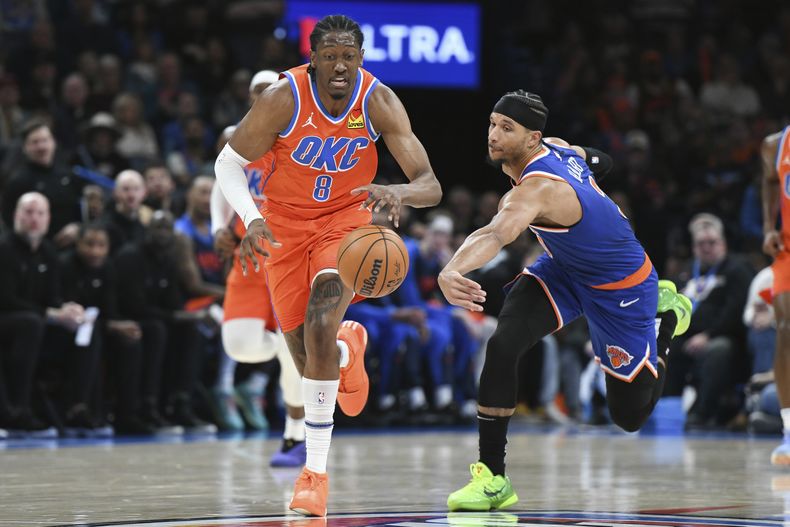 Jalen Williams, izquierda, del Thunder de Oklahoma City, pasa al lado de Josh Hart, derecha, de los Knicks de Nueva York, durante la segunda mitad del juego de baloncesto de la NBA, el viernes 3 de enero de 2025, en Oklahoma City. (AP Foto/Kyle Phillips)