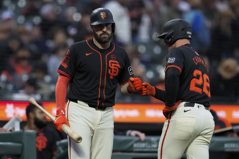 Matt Chapman, de los Gigantes de San Francisco, a la derecha, celebra con Curt Casali después de anotar contra los Rockies de Colorado con un doble de Brett Wisely durante la segunda entrada del segundo juego de una doble cartelera el sábado 27 de julio de 2024, en San Francisco. (AP Foto/Godofredo A. Vásquez)