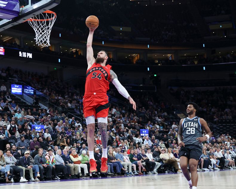 Sandro Mamukelashvili (54), de los Raptors de Toronto, se alza para clavar el balón en el partido de baloncesto de la NBA frente al Jazz de Utah, en la segunda mitad, el lunes 23 de marzo de 2026, en Salt Lake City. (AP Foto/Rob Gray)