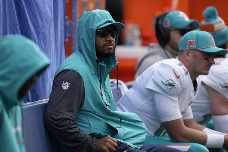 El quarterback de los Dolphins de Miami, Tua Tagovailoa, centro, observa desde la banca durante la primera mitad de un partido de fútbol americano de la NFL contra los Seattle Seahawks, el domingo 22 de septiembre de 2024, en Seattle. (AP Foto/Stephen Brashear)