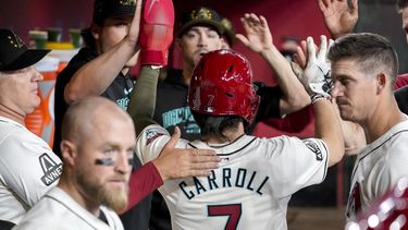 Corbin Carroll (7), de los Diamondbacks de Arizona, choca los cinco con sus compañeros de equipo después de anotar su primera carrera contra los Tigres de Detroit durante la primera entrada de un juego de béisbol, el domingo 19 de mayo de 2024, en Phoenix. Carroll estaba a salvo. (AP Foto/Darryl Webb)
