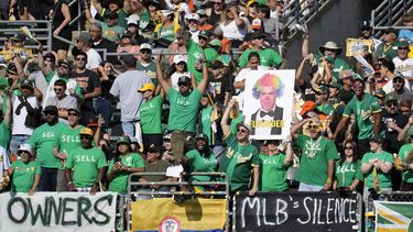 ARCHIVO - Foto del 5 de agosto del 2023, aficionados de los Atléticos de Oakland gritan y colocan pancartas pidiéndole al dueño que venda al equipo y lo mantenga en Oakland durante el encuentro ante los Gigantes de San Francisco. El miércoles 15 de noviembre del 2023, los dueños votarán el jueves sobre la posible mudanza del equipo a Las Vegas. (AP Foto/Jeff Chiu, Archivo)