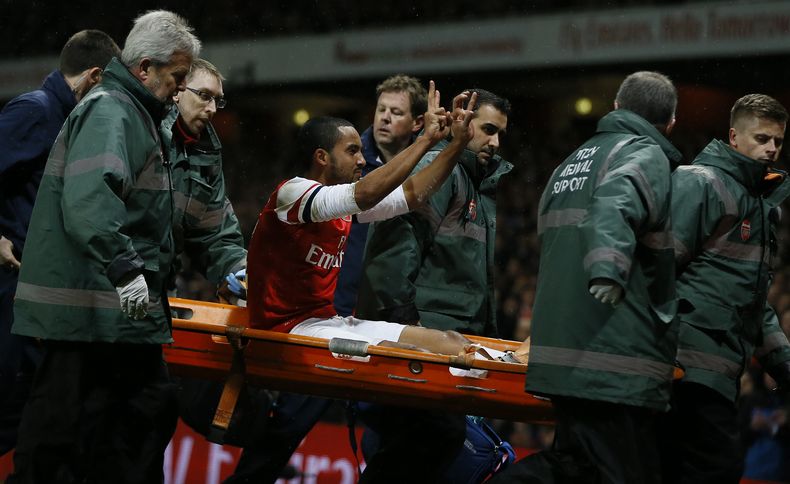 Theo Walcott del Arsenal saluda a la afici&oacute;n tras salir de la cancha en camilla en el partido contra Tottenham por la Copa de la FA el s&aacute;bado 4 de enero de 2014. (AP Foto/Kirsty Wigglesworth)