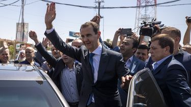 ARCHIVO - El presidente sirio Bashar Assad saluda a sus partidarios en una casilla electoral en Douma, cerca de Damasco, Siria, 26 de mayo de 2021. La justicia francesa emitió órdenes de arresto por crímenes de guerra para Assad, su hermano Maher y dos generales sirios el miércoles 15 de noviembre de 2023. (AP Foto/Hassan Ammar, File)