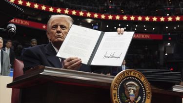 El presidente Donald Trump firma una orden ejecutiva durante un desfile bajo techo por la inauguración presidencial en el estadio Capital One, el lunes 20 de enero de 2025, en Washington. (AP Foto/Evan Vucci)