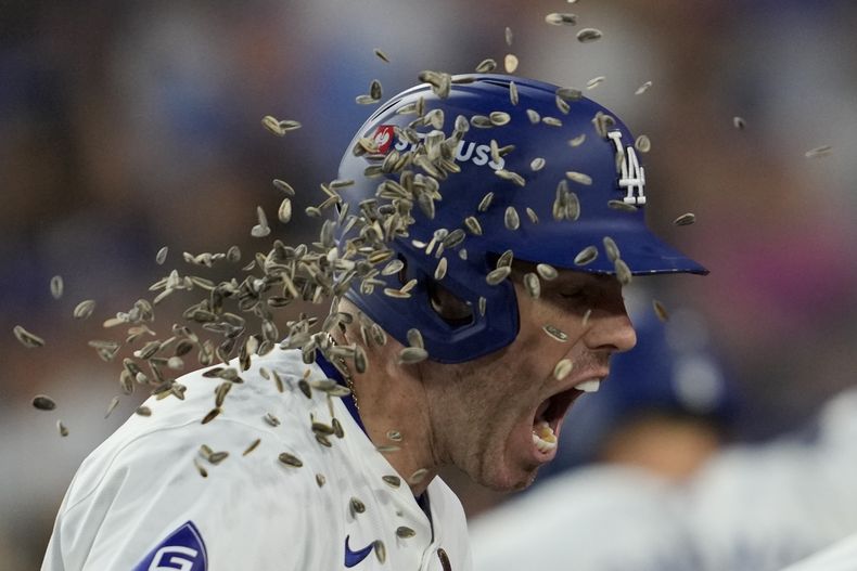 Freddie Freeman, de los Dodgers de Los Ángeles, festeja con semillas de girasol tras conectar un jonrón ante los Yankees de Nueva York en el primer juego de la Serie Mundial, el sábado 26 de octubre de 2024 (AP Foto/Ashley Landis)