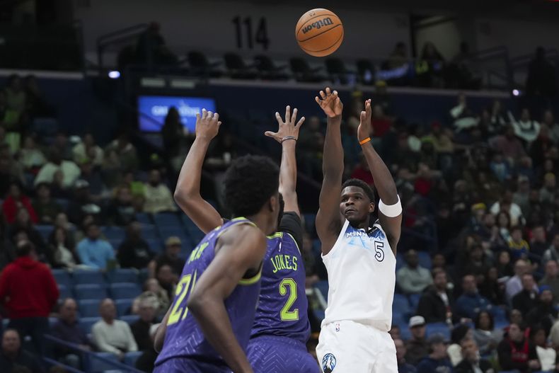 El escolta de los Timberwolves de Minnesota, Anthony Edwards (5), dispara contra el alero de los Pelicans de Nueva Orleans Herbert Jones (2) en la primera mitad de un partido de baloncesto de la NBA en Nueva Orleans, el martes 7 de enero de 2025. (AP Foto/Gerald Herbert)