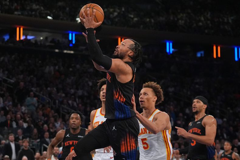 Jalen Brunson, de los Knicks de Nueva York, avanza superando a Dyson Daniels (5), de los Hawks de Atlanta, durante la primera mitad del quinto juego de una serie de la primera ronda de los playoffs de la NBA, el martes 28 de abril de 2026, en Nueva York. (AP Foto/Frank Franklin II)