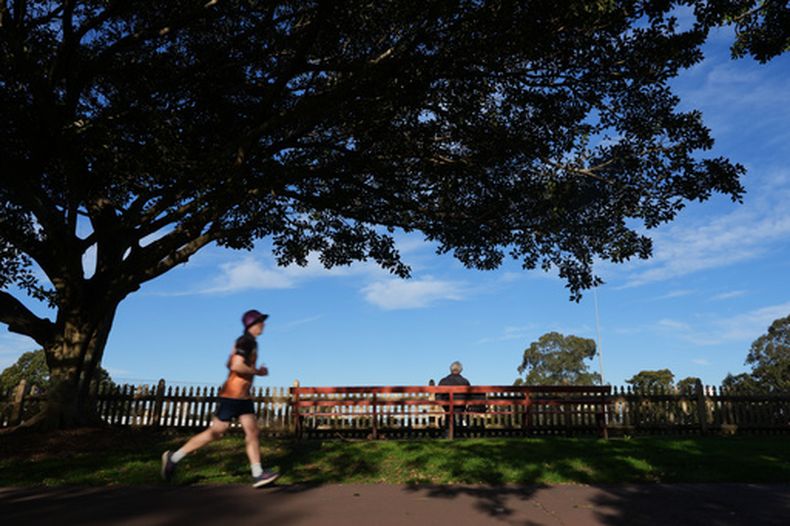 Un hombre trota en un parque el jueves 6 de agosto de 2026 cerca del centro de Sydney. (AP Foto/Mark Baker)