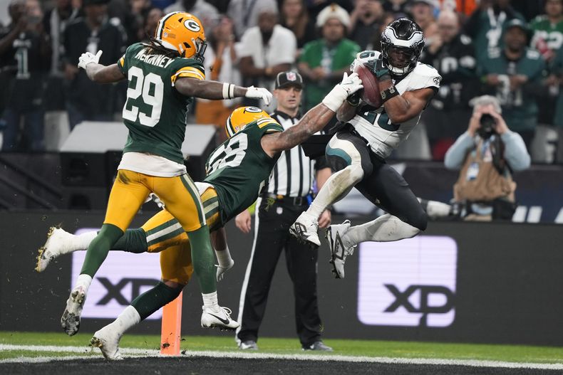 Saquon Barkley (26), running back de los Eagles de Filadelfia, anota un touchdown superando al linebacker Isaiah McDuffie (58), de los Packers de Green Bay, durante la primera mitad del partido de la NFL del viernes 6 de septiembre de 2024, en la Arena Neo Quimica, en Sao Paulo, Brasil. (AP Foto/Doug Benc)