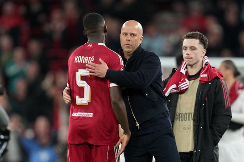 El técnico de Liverpool Arne Slot (centro) saluda a Ibrahima Konate al final del partido contra Galatasaray en los octavos de final de la Liga de Campeones, el miércoles 18 de marzo de 2026. (AP Foto/Jon Super)