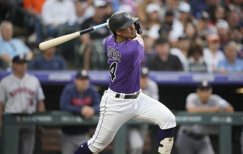 El venezolano Ezequiel Tovar batea un triple por los Rockies de Colorado ante los Astros de Houston, el martes 18 de julio de 2023 (AP Foto/David Zalubowski)