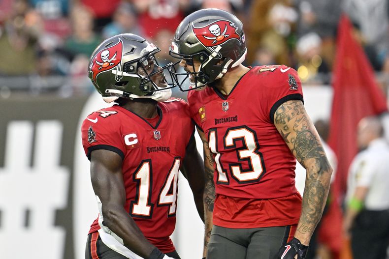El wide receiver de los Buccaneers de Tampa Bay Mike Evans (13) celebra su recepción de touchdown para 22 yardas ante los Jaguars de Jacksonville junto a su compañero de equipo el wide receiver Chris Godwin (14) durante la primera mitad del juego de la NFL el domingo 24 de diciembre de 2023, en Tampa, Florida. (AP Foto/Jason Behnken)