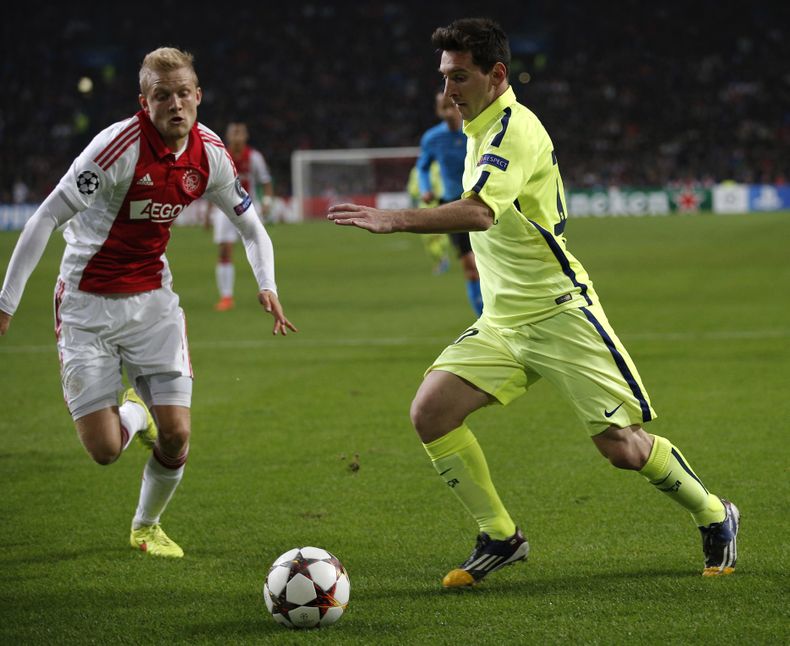 Lionel Messi del Barcelona disputa un bal&oacute;n con Nicolai Boilesen del Ajax, izquierda, en el partido por el Grupo F de la Liga de Campeones, en Amsterdam, el mi&eacute;rcoles 5 de noviembre de 2014. (AP Foto/Peter Dejong)