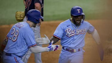 El cubano Adolis García (derecha) celebra junto a Jonah Heim (izquierda) luego de anotar la carrera de la ventaja en la octava entrada del juego ante los Guardianes de Cleveland, en Arlington, Texas. Domingo 16 de julio de 2023. (AP Foto/Gareth Patterson)