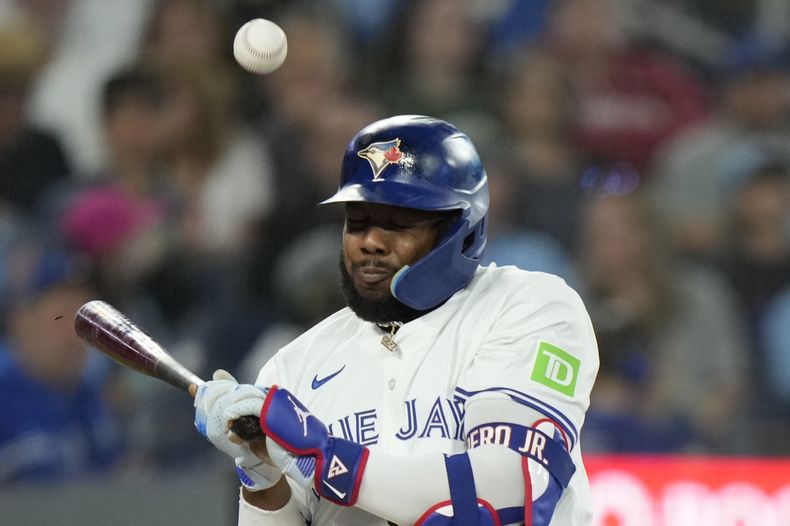 Vladimir Guerrero Jr., de los Azulejos de Toronto, es golpeado por un lanzamiento durante la tercera entrada contra los Yankees de Nueva York en Toronto, el domingo 30 de junio de 2024. (Frank Gunn/The Canadian Press vía AP)