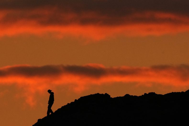 La silueta de una persona se ve al atardecer en el Parque Papago de Phoenix, Estados Unidos, el jueves 2 de marzo de 2023. La tasa de homicidios de adolescentes mayores en Estados Unidos subió a su punto más alto en casi 25 años durante la pandemia del COVID-19 y la tasa de suicidio de adultos al inicio de la veintena fue la más alta en más de 50 años, según dijeron el jueves investigadores del gobierno. (AP Foto/Charlie Riedel)