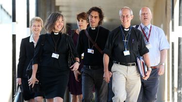 americateve | El arzobispo de Canterbury, Justin Welby, segundo de la derecha, y miembros no identificados del clero llegan a la reuni&oacute;n del S&iacute;nodo General en la Universidad de York, Inglaterra, el lunes 14 de julio del 2014. La Iglesia votar&aacute; para
