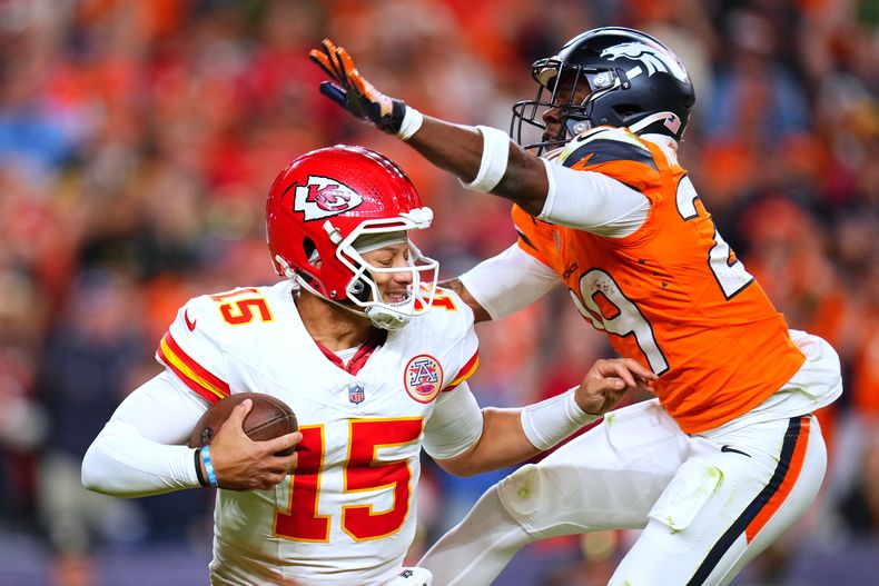 JaQuan McMillian, derecha, captura detrás de la línea a Patrick Mahomes (15), quarterback de los Broncos de Denver, durante la segunda mitad del partido de la NFL del domingo 16 de noviembre de 2025, en Denver. (AP Foto/Jack Dempsey)