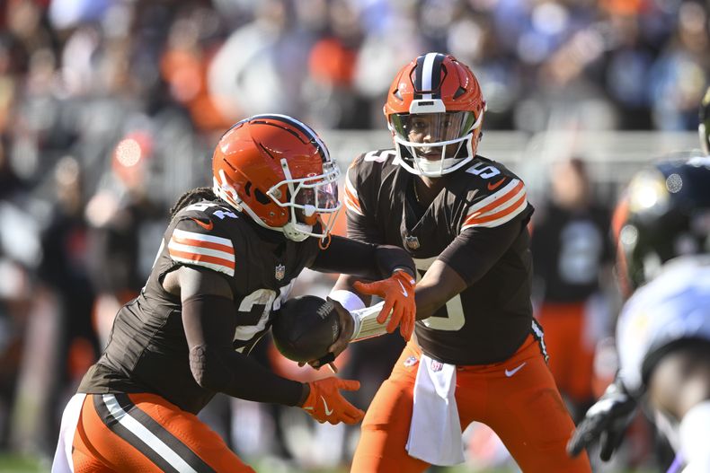 Jameis Winston (5), quarterback de los Browns de Cleveland, le entrega el balón al running back DOnta Foreman (27) durante la segunda mitad del juego de la NFL en contra de los Ravens de Baltimore, el domingo 27 de octubre de 2024, en Cleveland. (AP Foto/David Richard)