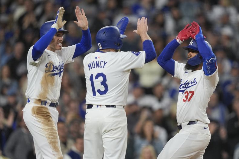 El jugador de los Dodgers de Los Ángeles Teoscar Hernández (37) celebra su jonrón de tres carreras con Max Muncy (13) y Freddie Freeman en el sexto inning de su juego contra los Gigantes de san Francisco el lunes 1 de abril de 2024, en Los Ángeles. Max Muncy y Freddie Freeman también anotaron. (AP Foto/Ryan Sun)