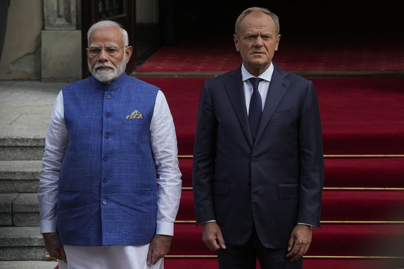 El primer ministro de India, Narendra Modi, izquierda, junto a su homólogo polaco, Donald Tusk, pasan revista a una guardia de honor antes de sostener conversaciones en Varsovia, Polonia, el jueves 22 de agosto de 2024. (AP Foto/Czarek Sokolowski)
