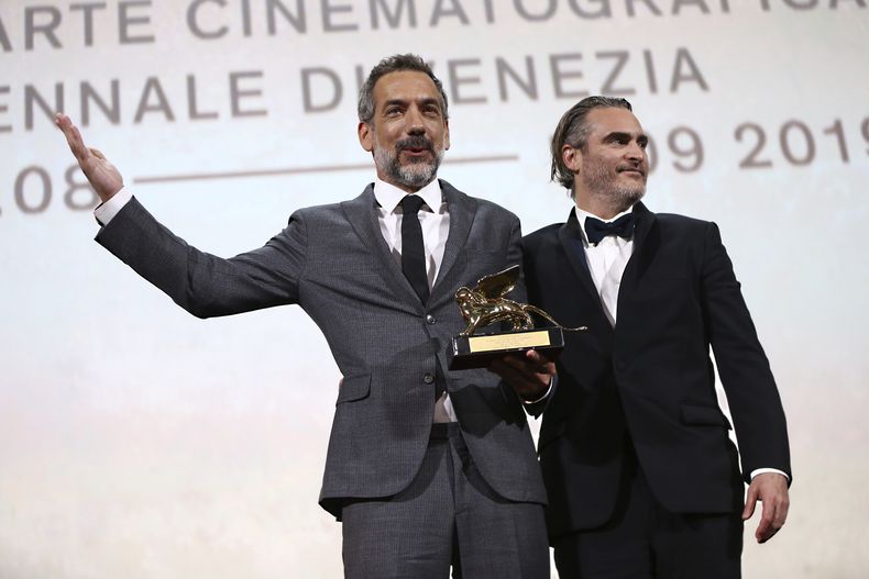 ARCHIVO - El director Todd Phillips, a la izquierda, sostiene el León de Oro a la mejor película por Joker, acompañado por el actor principal Joaquin Phoenix en la ceremonia de clausura de la 76.a edición del Festival de Cine de Venecia, Venecia, Italia, el 7 de septiembre de 2019. (Foto Joel C Ryan/Invision/AP, archivo)