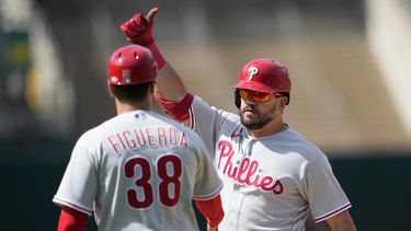 Kyle Schwarber (derecha) de los Filis de Filadelfia tras impulsar una carrera en el 12do inning ante los Atléticos de Oakland, el sábado 17 de junio de 2023, en Oakland. (AP Foto/Jeff Chiu)