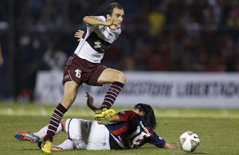 Fidencio Oviedo, de Cerro Porte&ntilde;o de Paraguay, elude a Leandro Somoza, de Lan&uacute;s de Argentina, durante un partido correspondiente a la fase de grupos de la Copa Libertadores, el mi&eacute;rcoles 26 de febrero de 2014, en Asunci&oacute;n (AP F