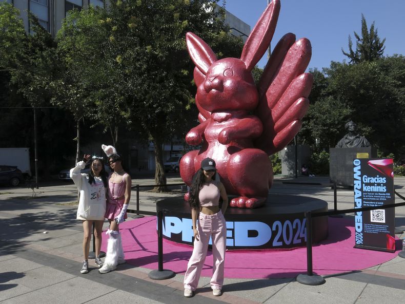 Fans posan frente a un conejo para celebrar el segundo año consecutivo de Kenia Os como la artista femenina mexicana más escuchada de Spotify en el año el jueves 5 de diciembre de 2024, en la Ciudad de México. (Foto AP/Berenice Bautista)