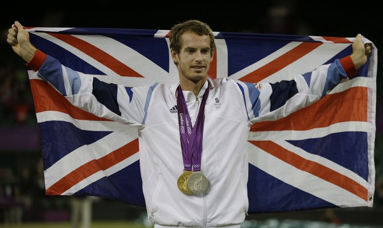 ARCHIVO - El tenista británico Andy Murray posa con su medallas de oro y plata en el All England Lawn Tennis Club en Wimbledon durante los Juegos Olímpicos de 2012, el domingo 5 de agosto de 2012. (AP Foto/Mark Humphrey)