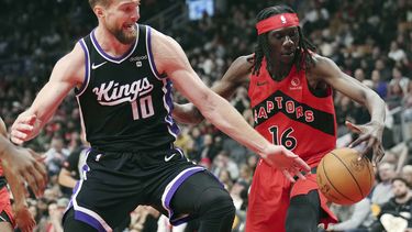 El ala-pívot de los Kings de Sacramento Domantas Sabonis (10) y el alero de los Raptors de Toronto Mouhamadou Gueye (16) disputan el balón durante la segunda mitad del juego de baloncesto de la NBA, en Toronto, el miércoles 20 de marzo de 2024. (Nathan Denette/The Canadian Press via AP)