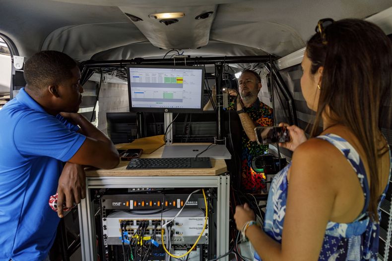 El equipo de Microsoft establece en una camioneta la primera prueba en vivo en Ghana de tecnología de telemedicina en tercera dimensión, el martes 25 de febrero de 2025, en el hospital de Koforidua, Ghana. (AP Foto/Misper Apawu)