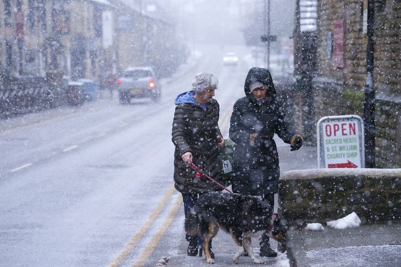 Unas mujeres caminan por una calle de Saddleworth, Inglaterra, el 7 de enero de 2025. (AP Foto/Jon Super)