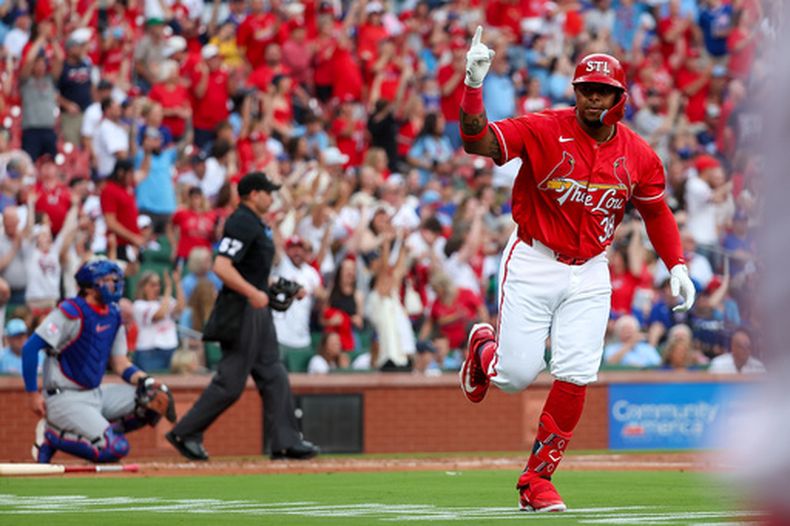 Nelson Velázquez, derecha, de los Cardenales de San Luis, señala y celebra con la caseta mientras corre las bases tras conectar un jonrón de tres carreras durante la primera entrada del juego de béisbol de Grandes Ligas contra los Cachorros de Chicago, el viernes 29 de mayo de 2026, en San Luis. (AP Foto/Scott Kane)