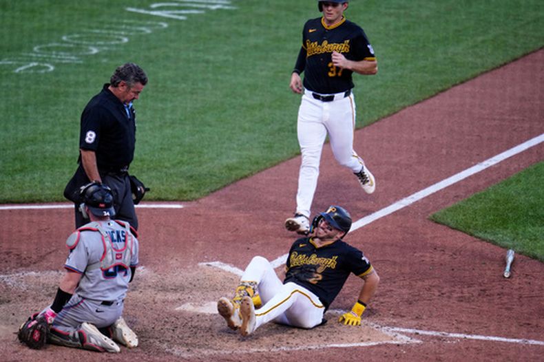 Spencer Horwitz (2), de los Piratas de Pittsburgh, reacciona después de haber sido golpeado por un lanzamiento de Anthony Bender, de los Marlins de Miami, forzando la carrera de la ventaja de Tyler Callihan (37) durante la octava entrada del juego de béisbol de Grandes Ligas, el sábado 13 de junio de 2026. (AP Foto/Gene J. Puskar)