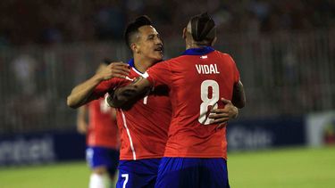 americateve | El jugador de la selecci&oacute;n de Chile y la Juventus, Arturo Vidal, de espa&ntilde;da, festeja con su compa&ntilde;ero Alexis S&aacute;nchez tras un gol de S&aacute;nchez ante Uruguay en un amistoso el martes, 18 de noviembre de 2014, en Santiago. (AP